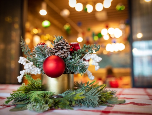 table adorned with festive christmas decorations, including candles, ornaments, and a beautiful center piece