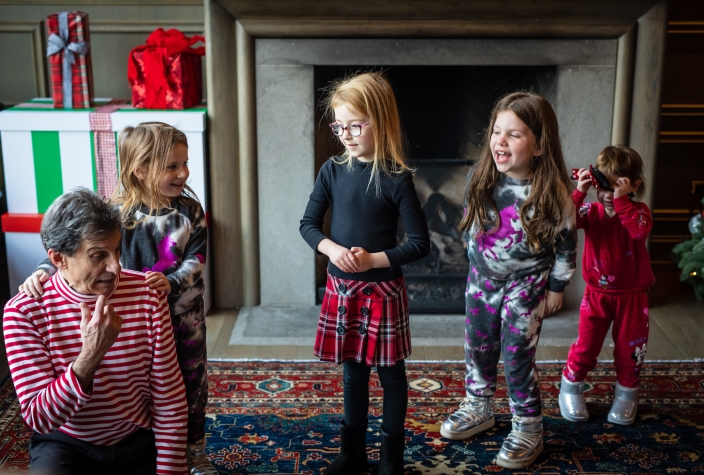 children gathered around a cozy fireplace, adorned with christmas stockings and holiday decorations.