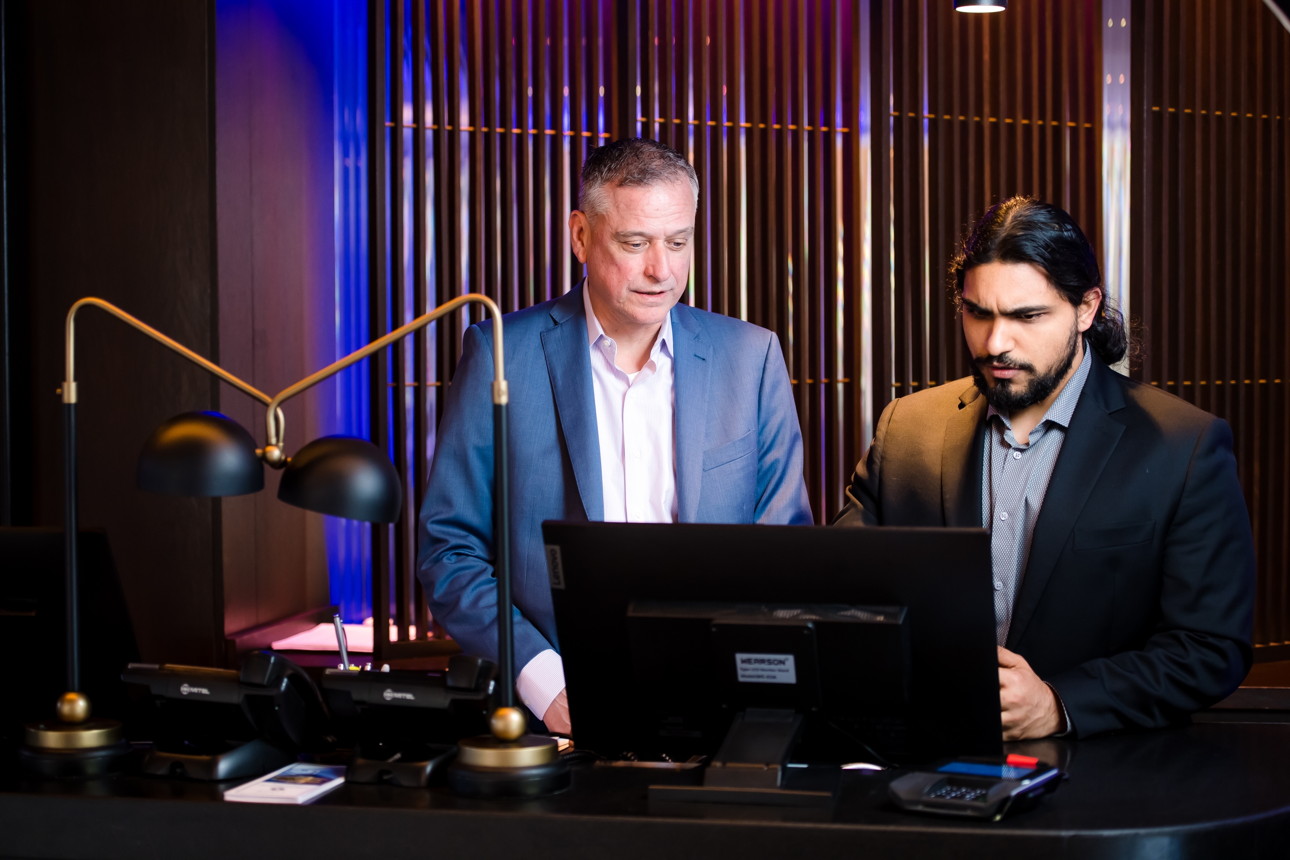 Two men in suites looking at a computer screen