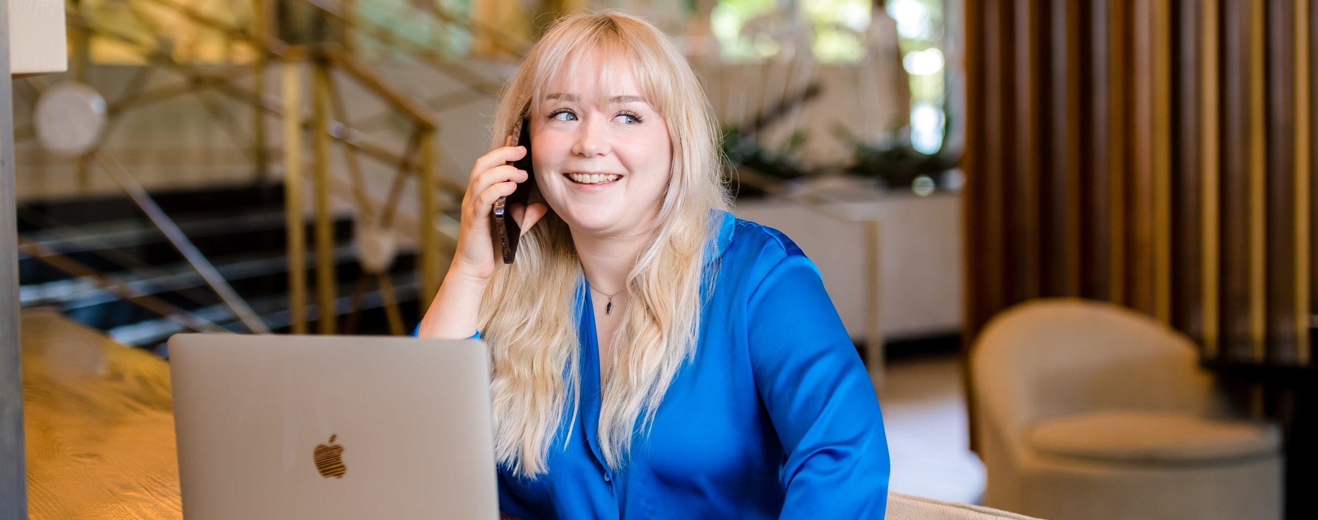 Business woman sitting at a table and speaking on a cell phone