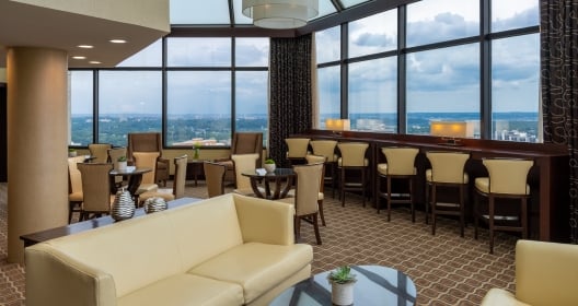 The dining restaurant at Hilton Alexandria Mark Center. The restaurant has large windows that overlook the city.