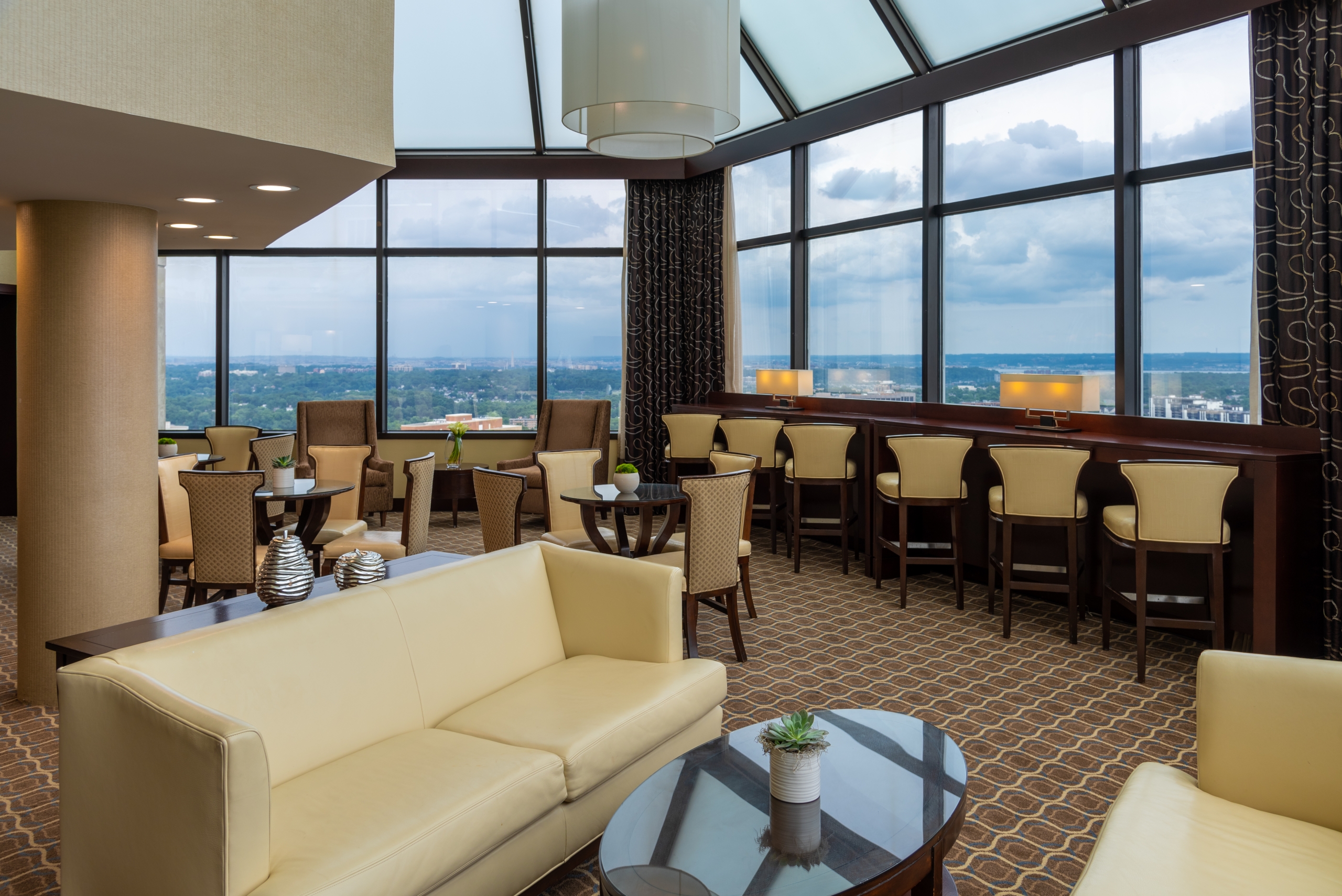 The dining restaurant at Hilton Alexandria Mark Center. The restaurant has large windows that overlook the city.