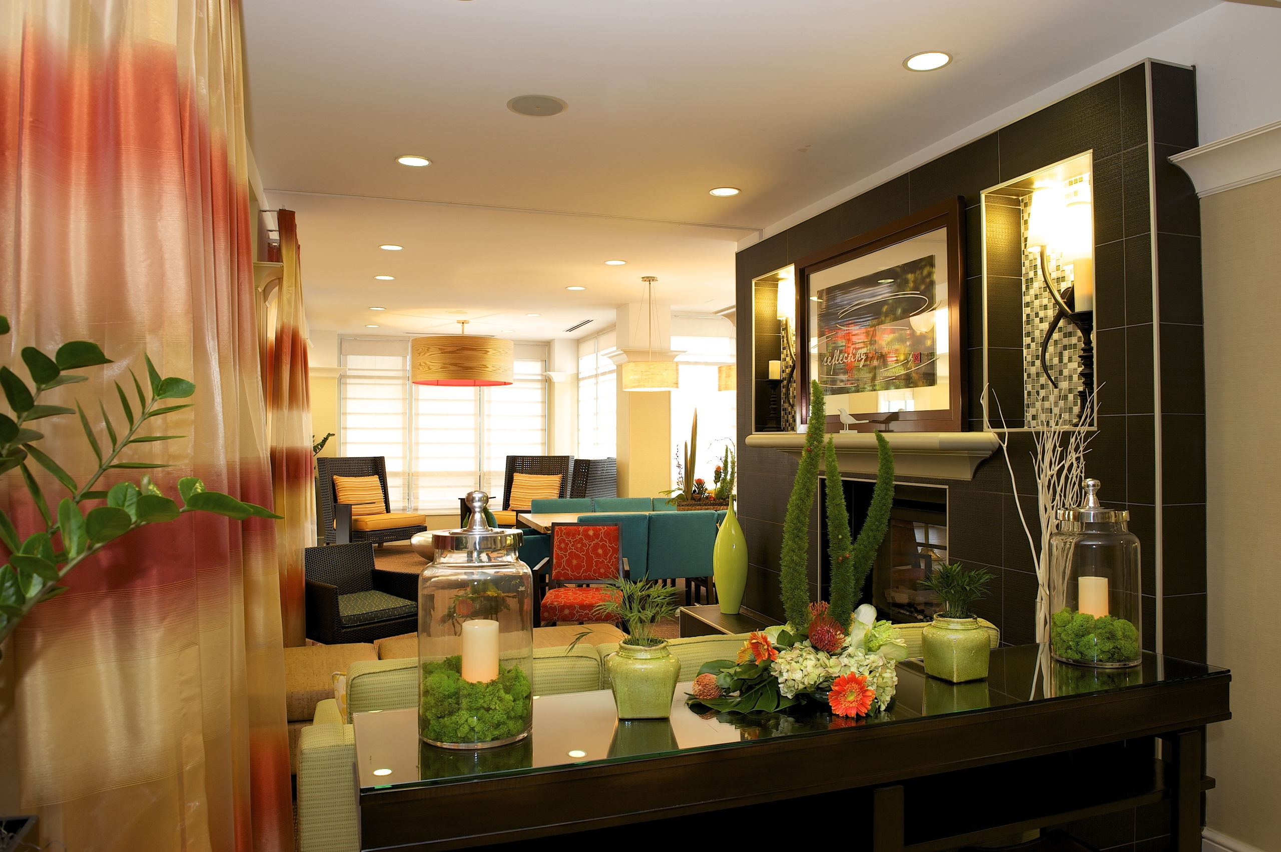 The lobby of the Hilton Garden Inn San Francisco hotel. The lobby is decorated with dark furnature and bright green plants.