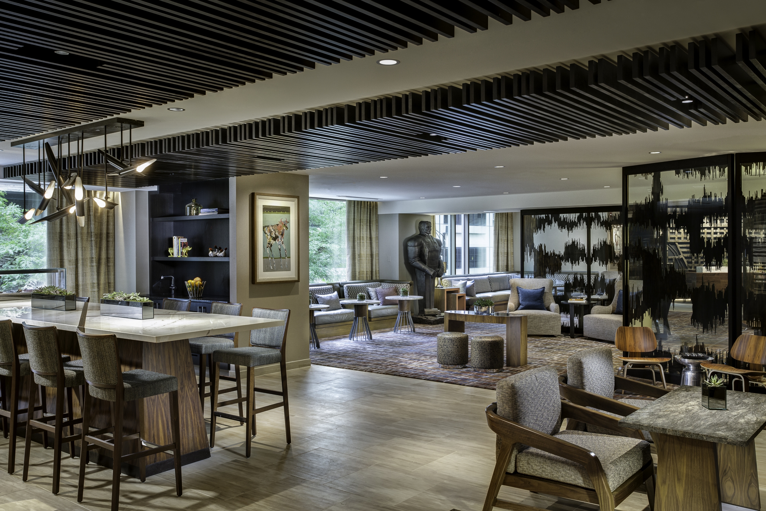 The Sushi bar and lobby at the Hyatt Centric Chicago Magnificent Mile hotel. The bar has high top tables with marble tops.