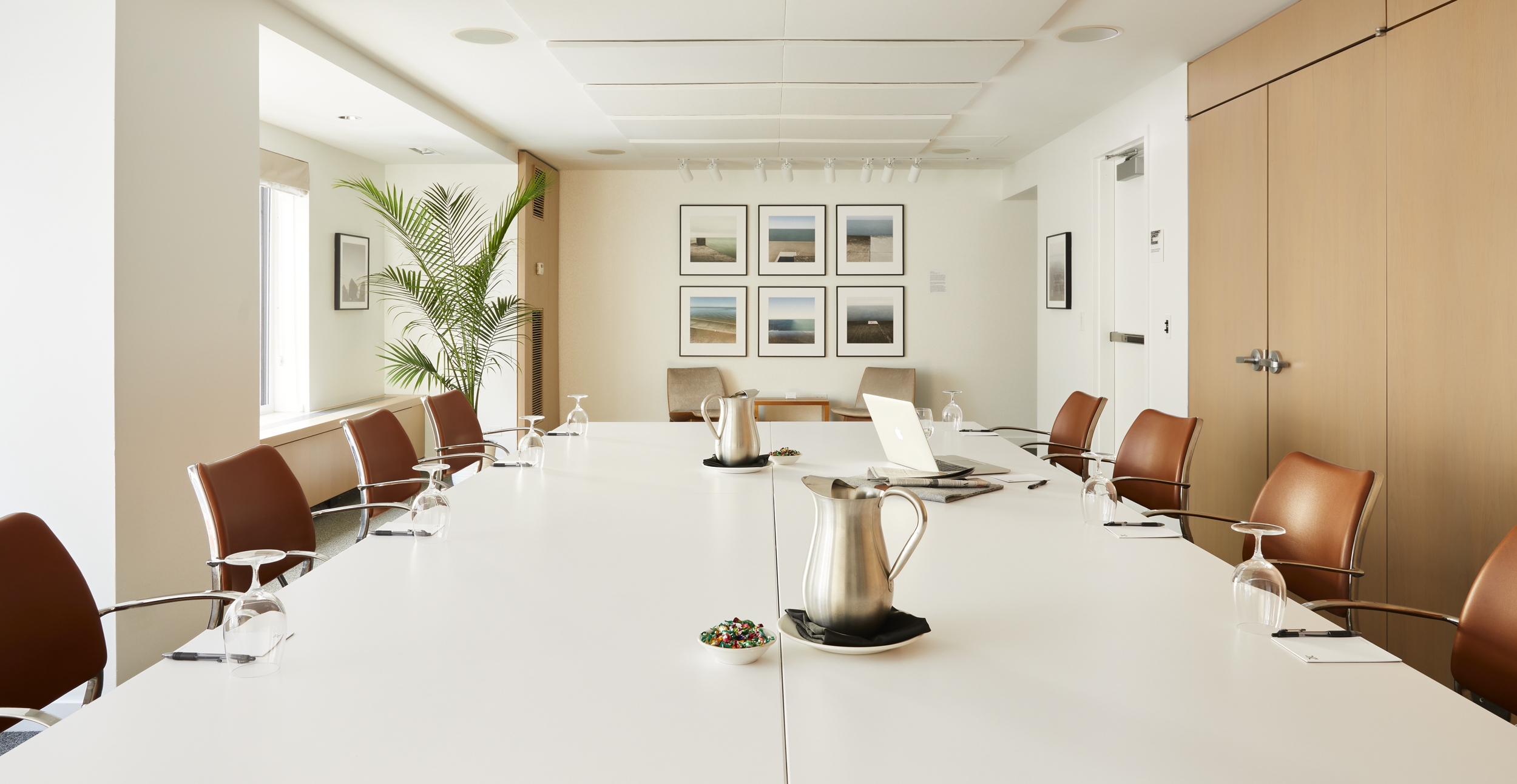 A large and spacious boardroom with pitchers or water
