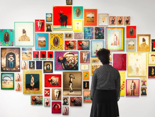 A woman looking at a wall of art in a gallery