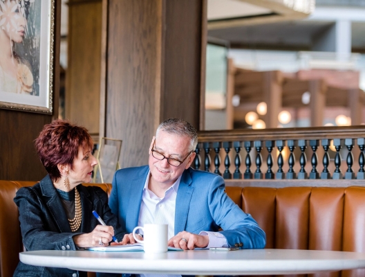 Man and woman having a conversation at a booth table.