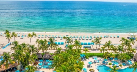 An aerial view of the beach as seen from the Margaritaville Hollywood Beach Resort hotel. In the foreground you can see two large pools.