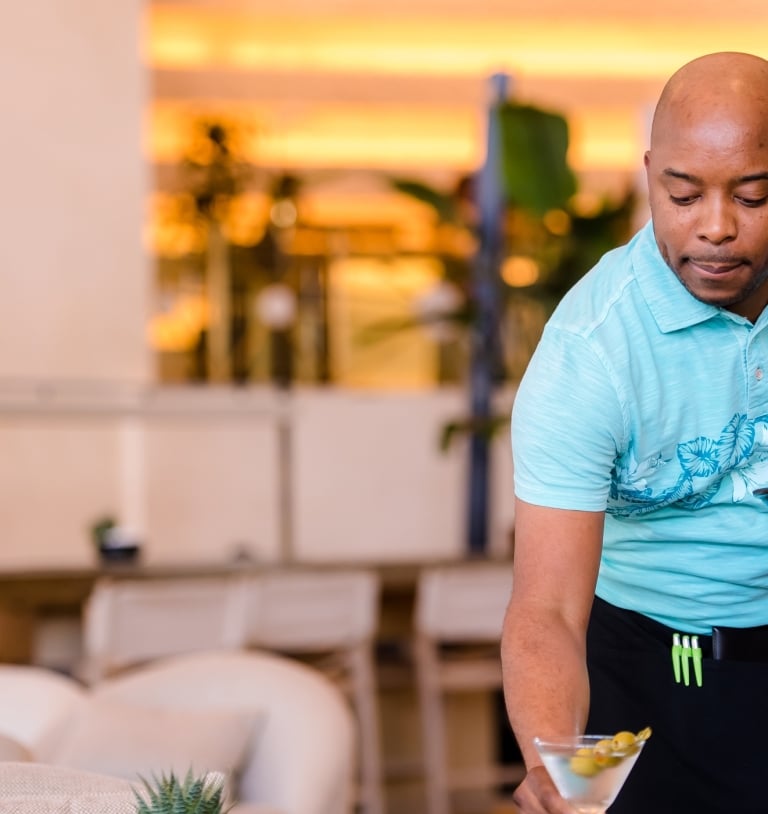 Man placing drink off of tray onto table