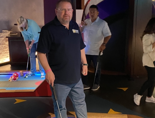 revenue manager enjoying a round of mini-golf, fostering team spirit and relaxation in the workplace