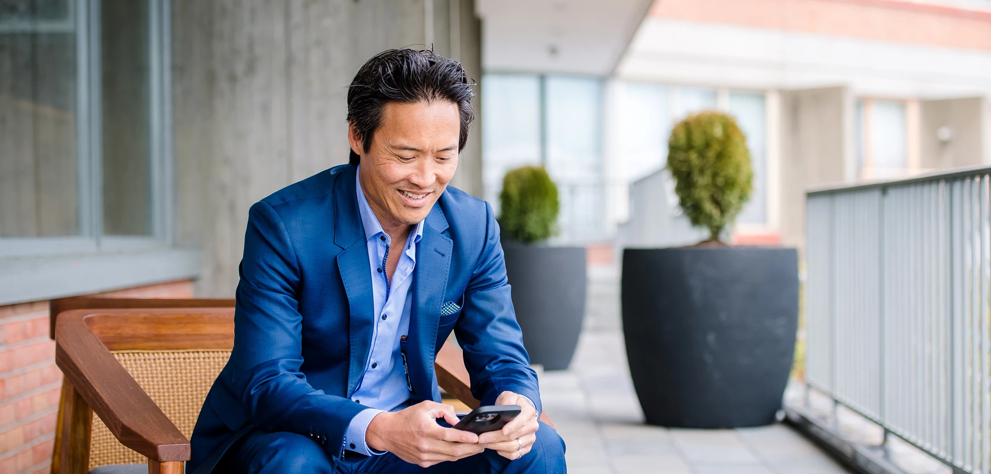 man sitting and looking down at cell phone