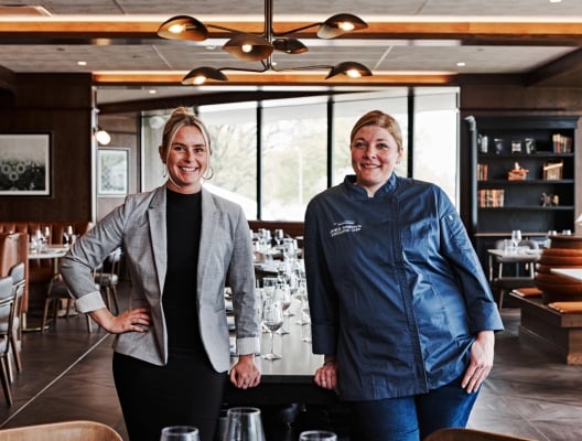 two women standing in restaurant