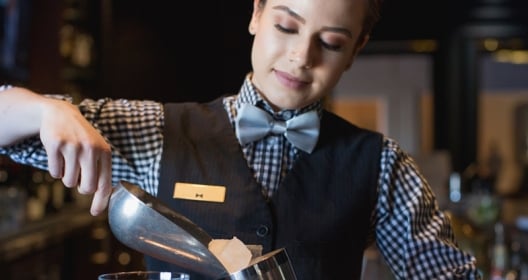 bartender adding ice to shaker