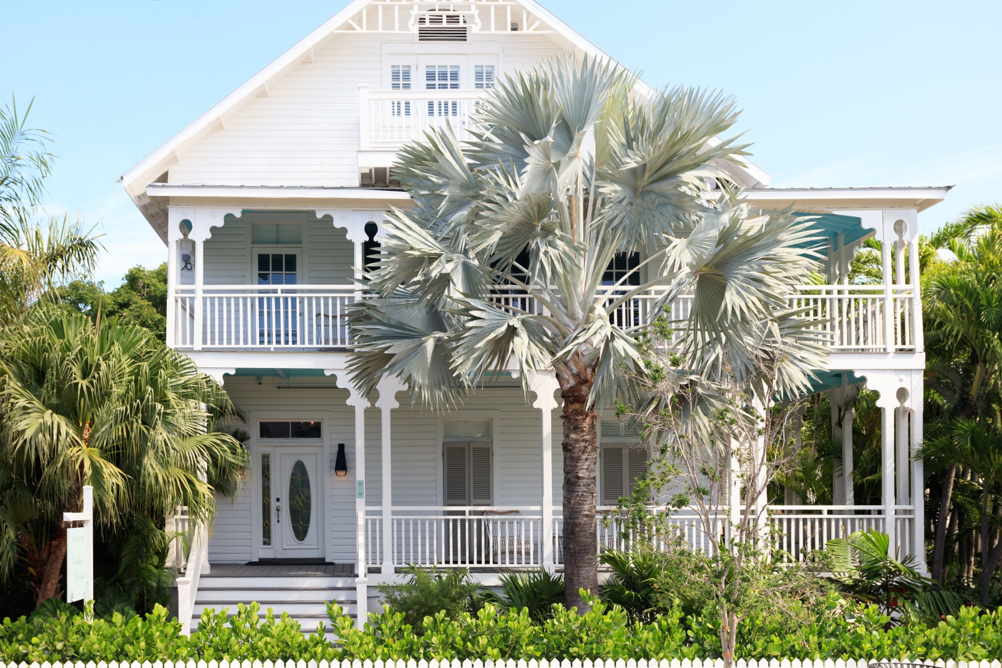 exterior of Winslow's Bungalows with colourful palm trees out front