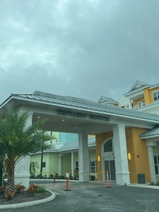 A covered entrance to Embassy Suites Orlando on a cloudy day