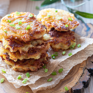 A stack of potato latkes topped with chives
